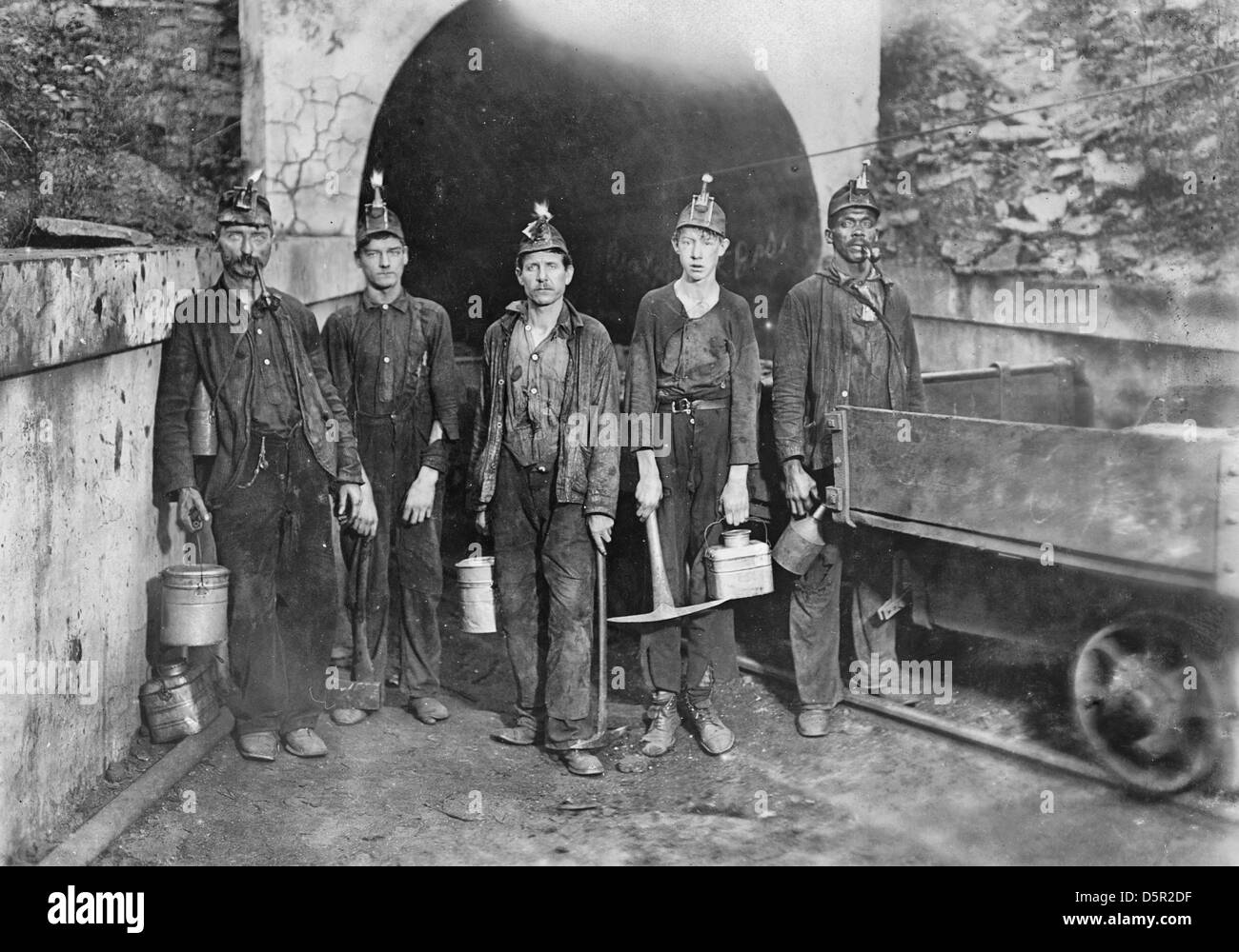 Main entrance, Gary West Virginia Mine. Trapper boy in center. Going to work 7 A.M. will be underground until 5:30 P.M. Trappers are paid $1. per day. Location: Gary, West Virginia, circa 1908 Stock Photo