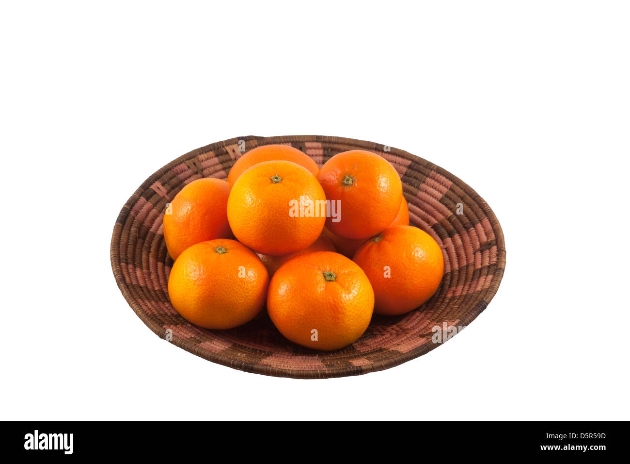 Organic mandarin oranges in African basket cutout on white background