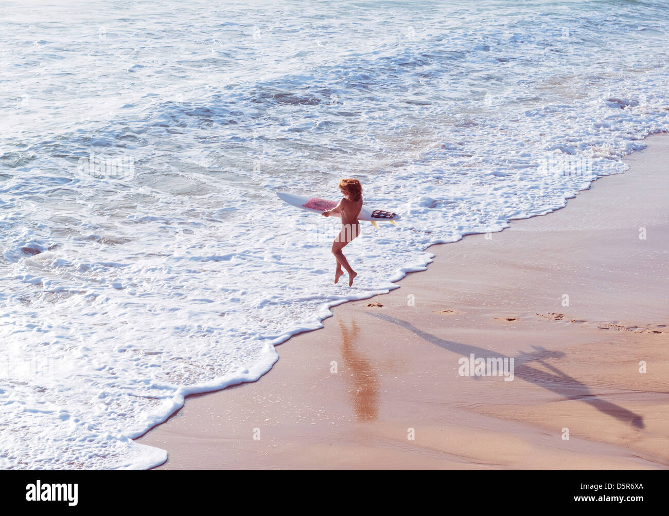 Nude woman running into the sea with a surf board. Tarifa, Costa de la Luz,  Cadiz, Andalusia, Spain, Europe Stock Photo - Alamy