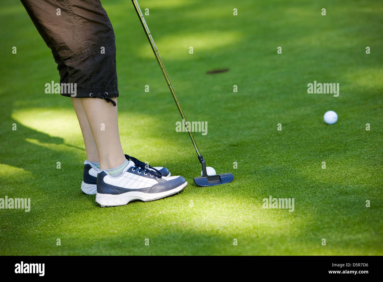 Closeup of junior golfer putting golf ball in to hole Stock Photo Alamy