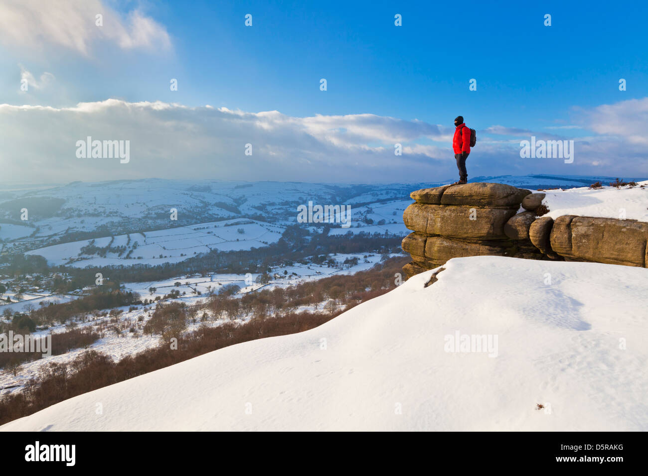 Hiker in snow covered peaks on Curbar Edge Peak District National Park Derbyshire England GB UK EU Europe Stock Photo