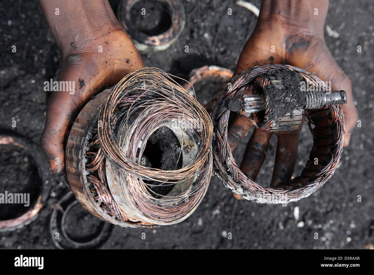 By fire exposed copper windings from a electronics. Agbogbloshie burning site for e-waste and used computers in Accra, Ghana Stock Photo