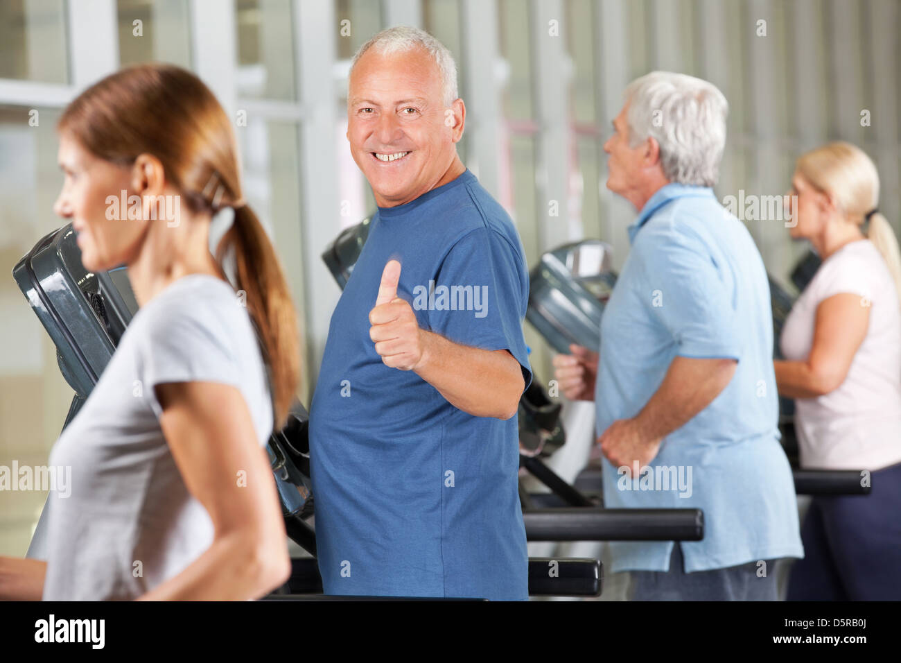 Happy senior man holding thumbs up on treadmill in gym Stock Photo - Alamy
