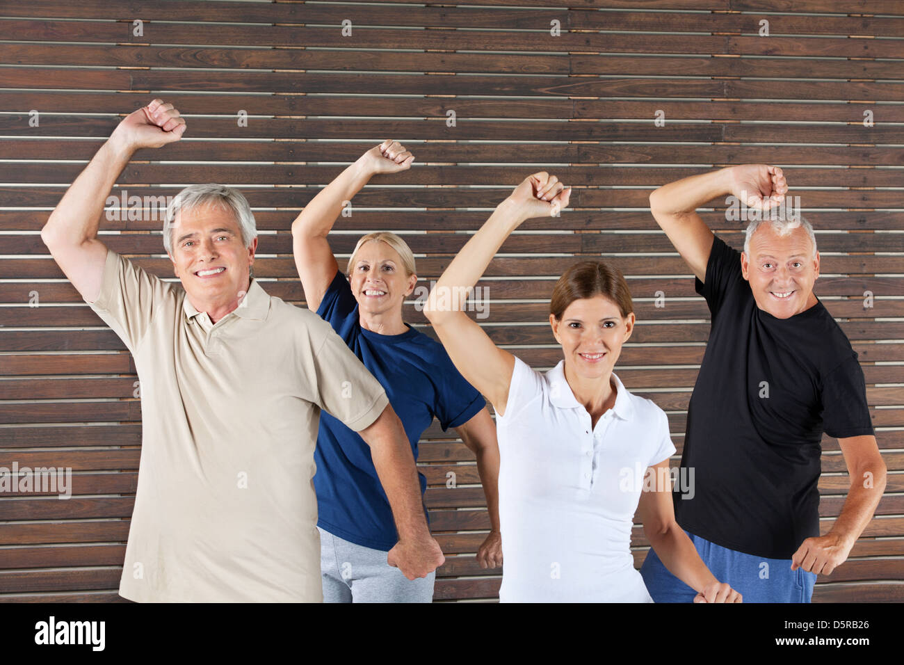 Happy senior group doing fitness exercises in gym Stock Photo