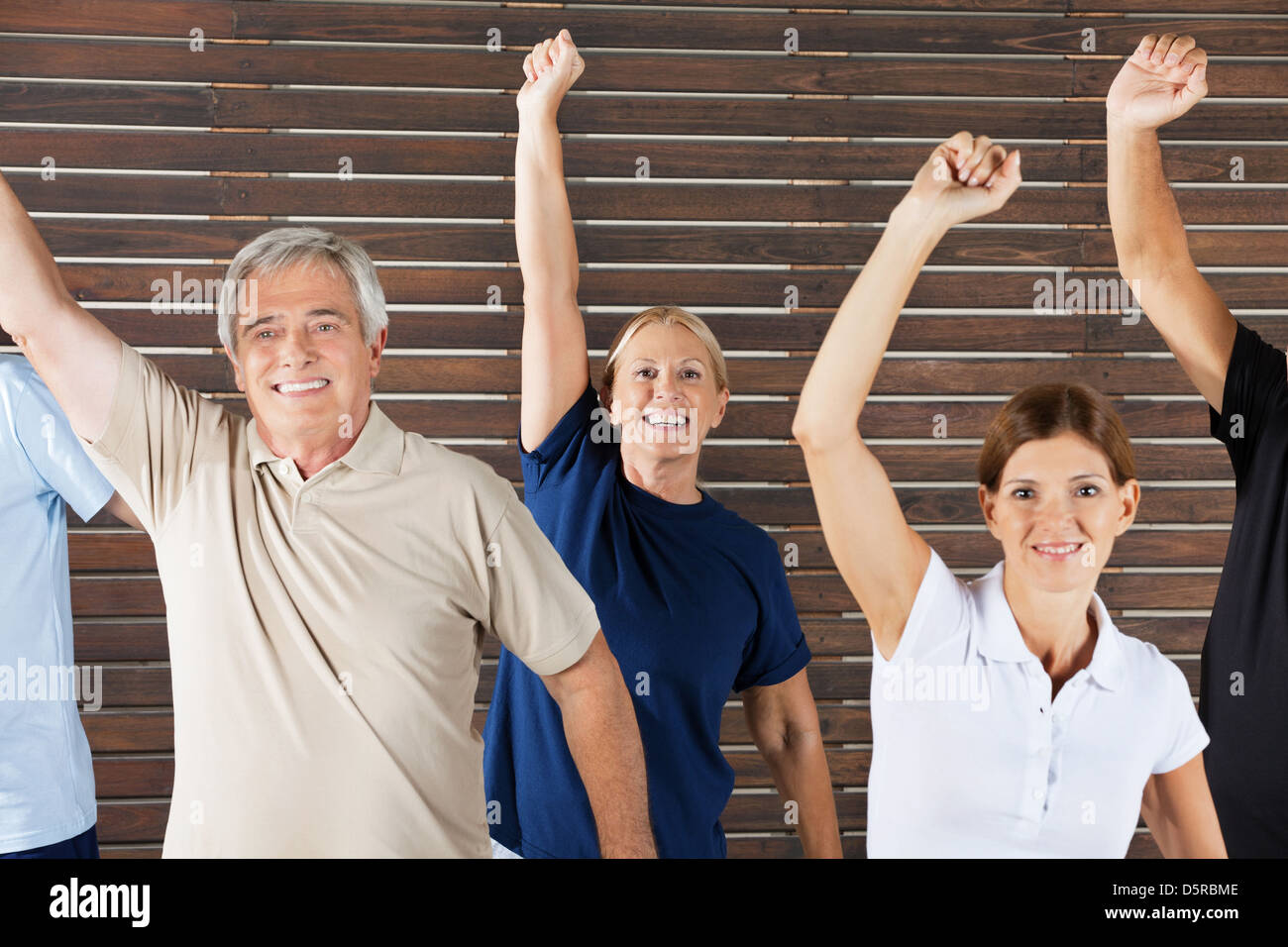 Cheering senior citizens at workout in fitness center gym Stock Photo