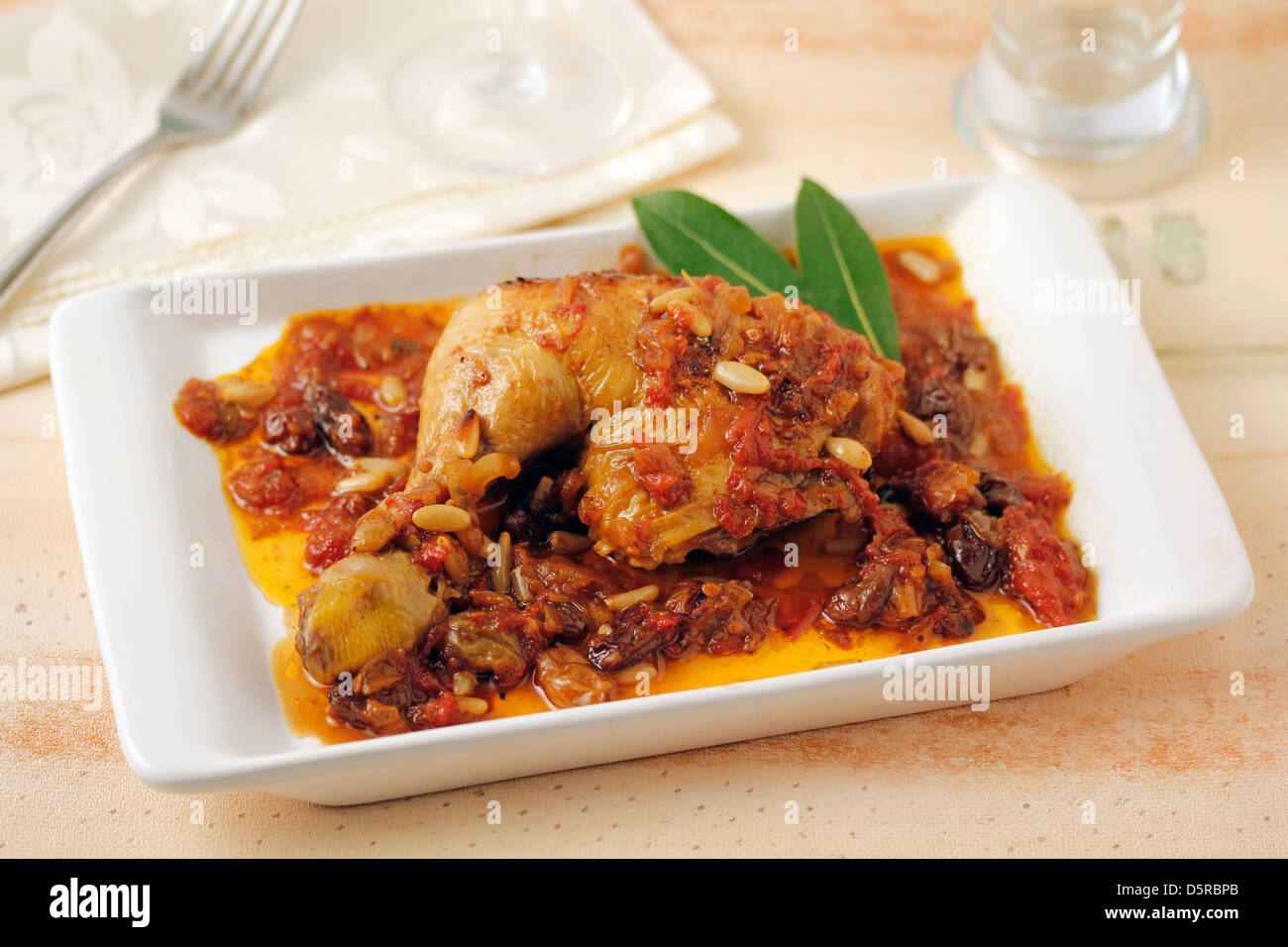 Chicken with raisins and pine nuts. Recipe available. Stock Photo