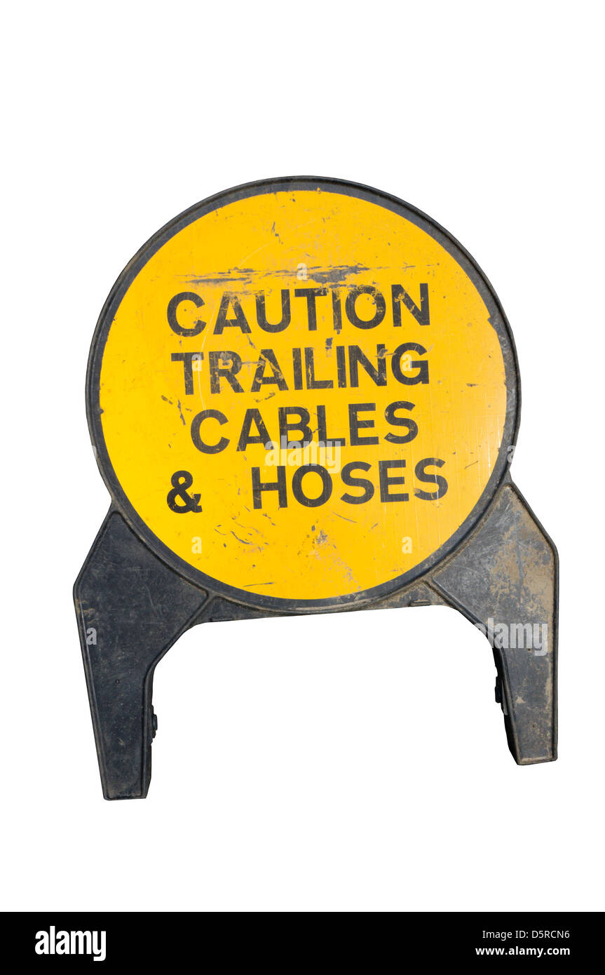 A sign warns of trailing cables and hoses in a dangerous working environment. Stock Photo
