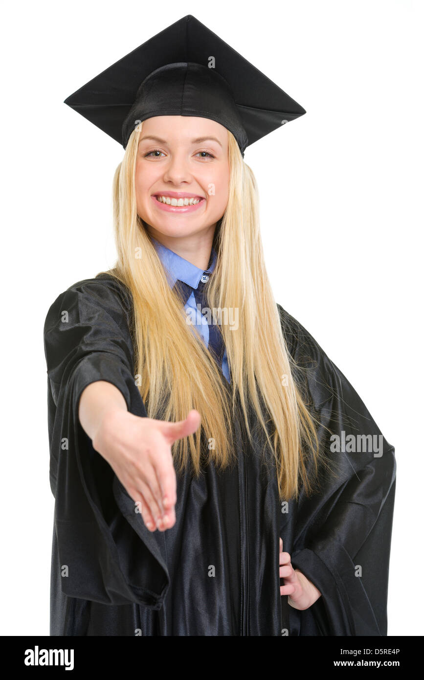 Smiling young woman in graduation gown stretching hand for handshake Stock Photo