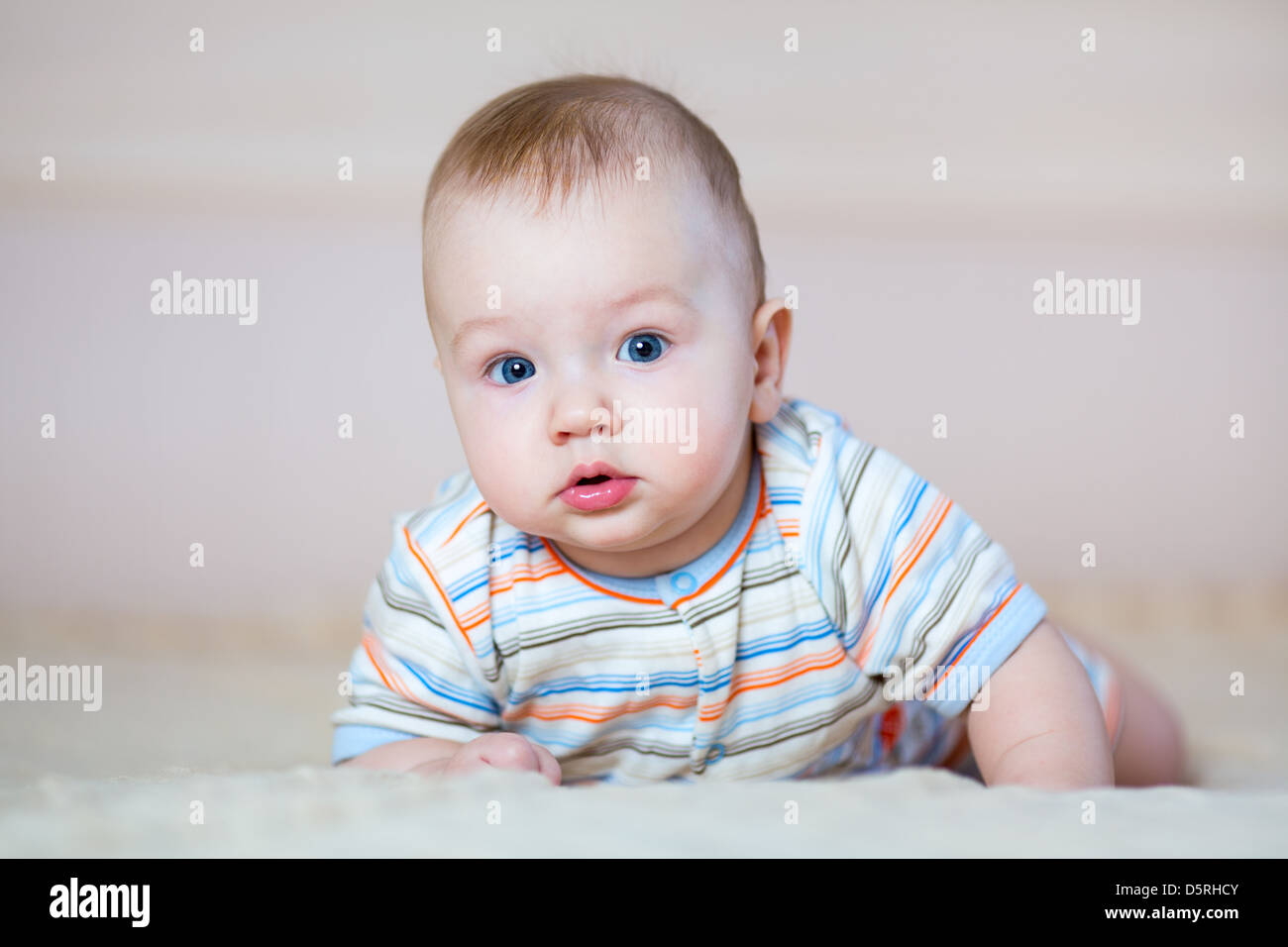 cute baby boy lying on stomach indoors Stock Photo Alamy