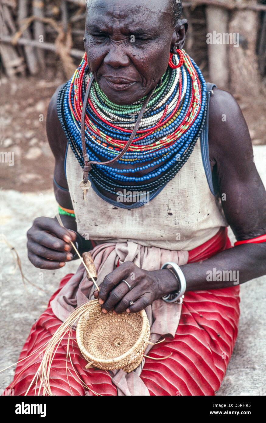 Portrait of a Samburu woman wearing traditional beads and weaving a