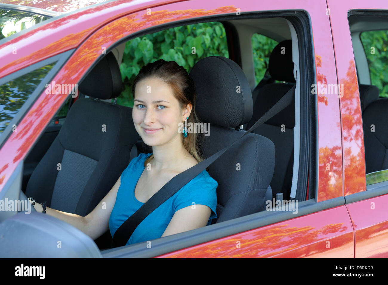 18 years old girl buckled up in the driver's seat of a car Stock Photo