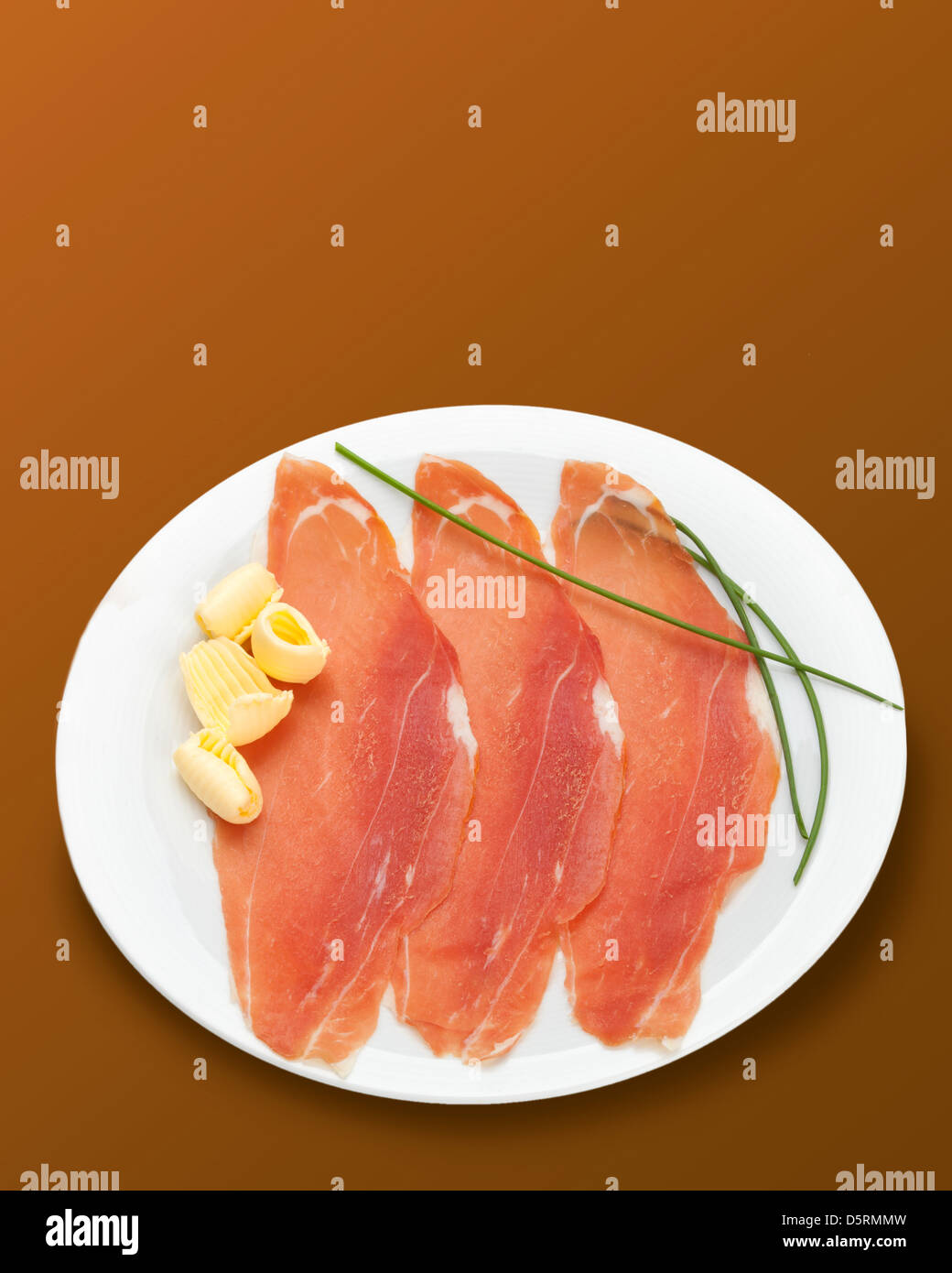 Raw ham on brown background Stock Photo