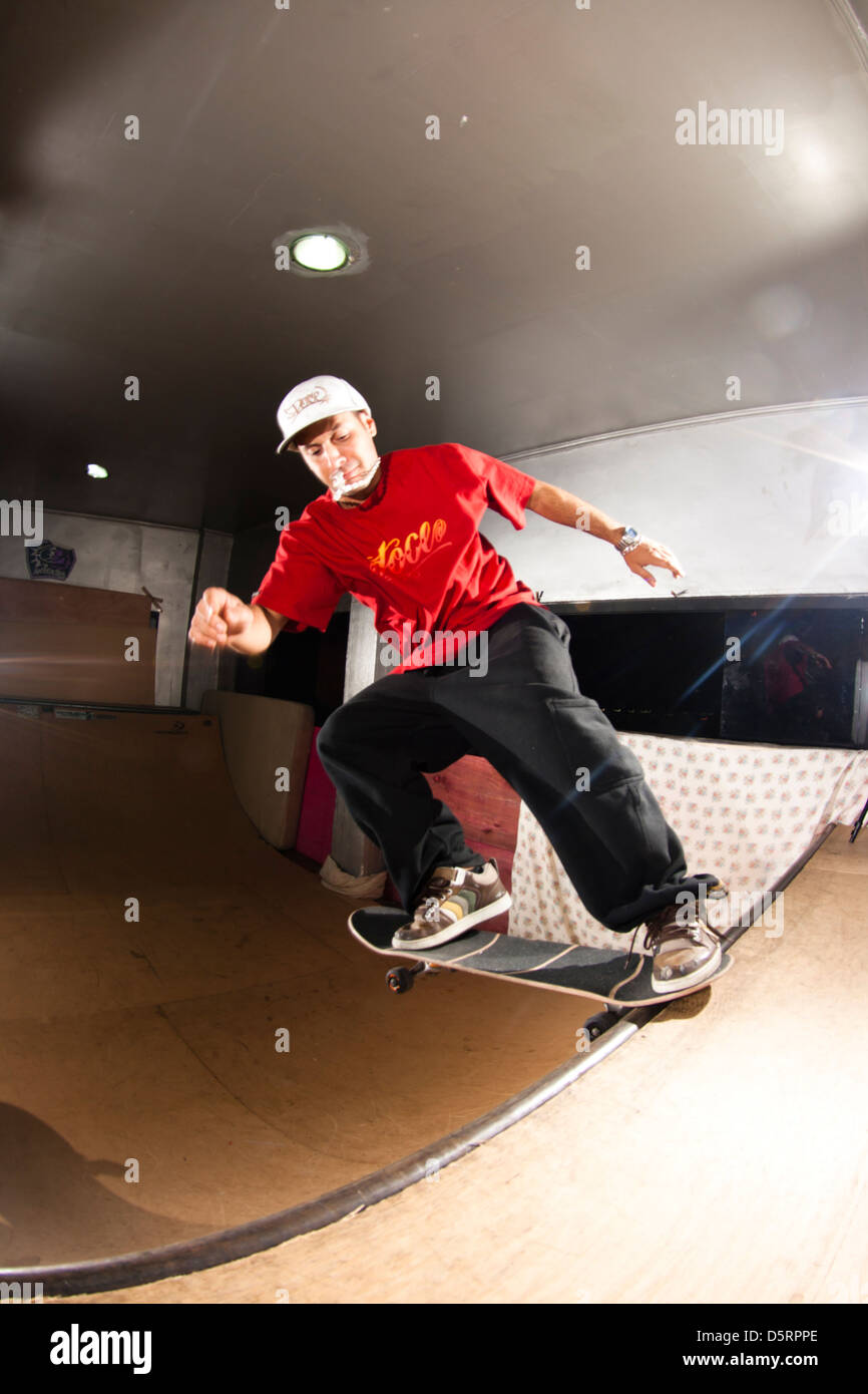 pro rider Rafael Tramonte 'Pingo' porforming  skateboard tricks in a mini wood made skate park.  São Vicente, Brazil. Stock Photo
