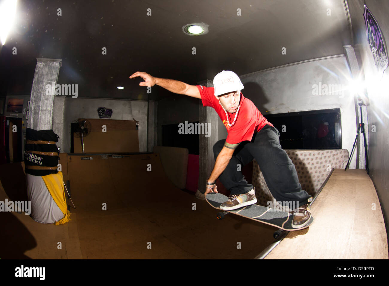 pro rider Rafael Tramonte 'Pingo' porforming  skateboard tricks in a mini wood made skate park.  São Vicente, Brazil. Stock Photo