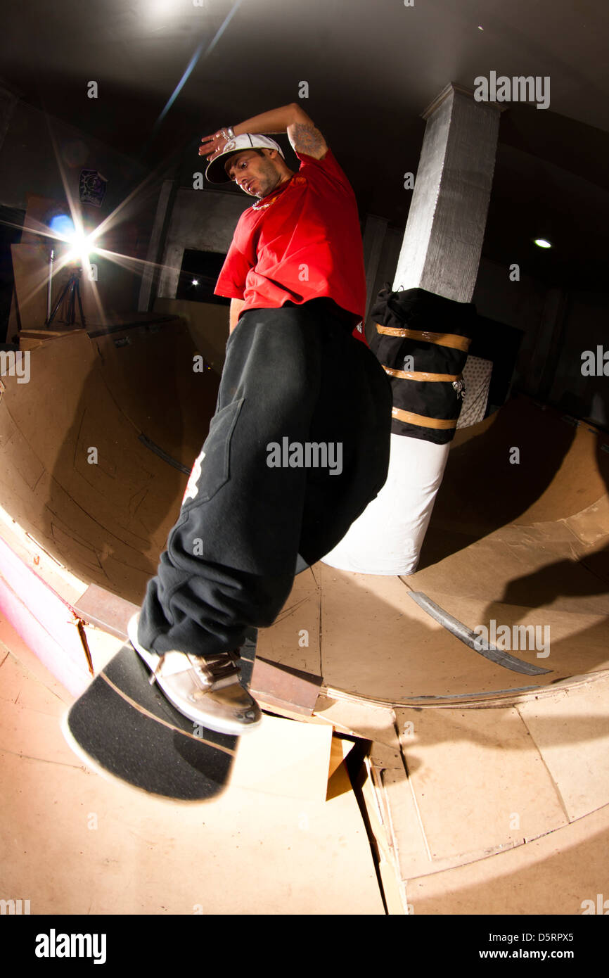 pro rider Rafael Tramonte 'Pingo' porforming  skateboard tricks in a mini wood made skate park.  São Vicente, Brazil. Stock Photo