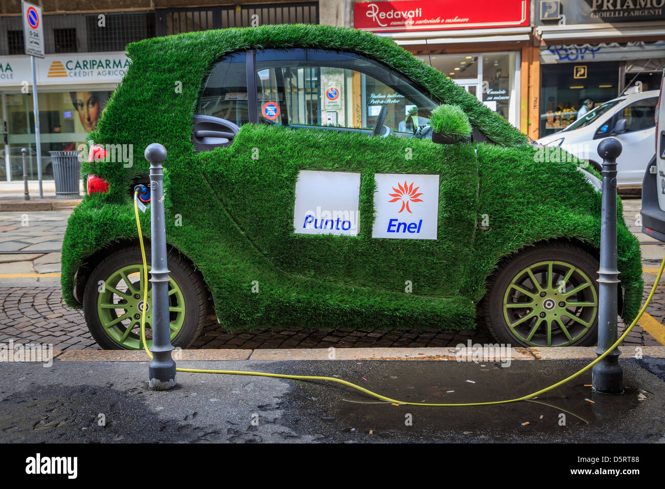 An electric Smart car with grass cover and Punto Enel markings, Milan, Italy Stock Photo