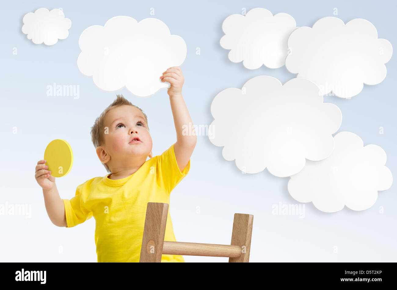 Kid attaching cloud to sky using ladder concept Stock Photo