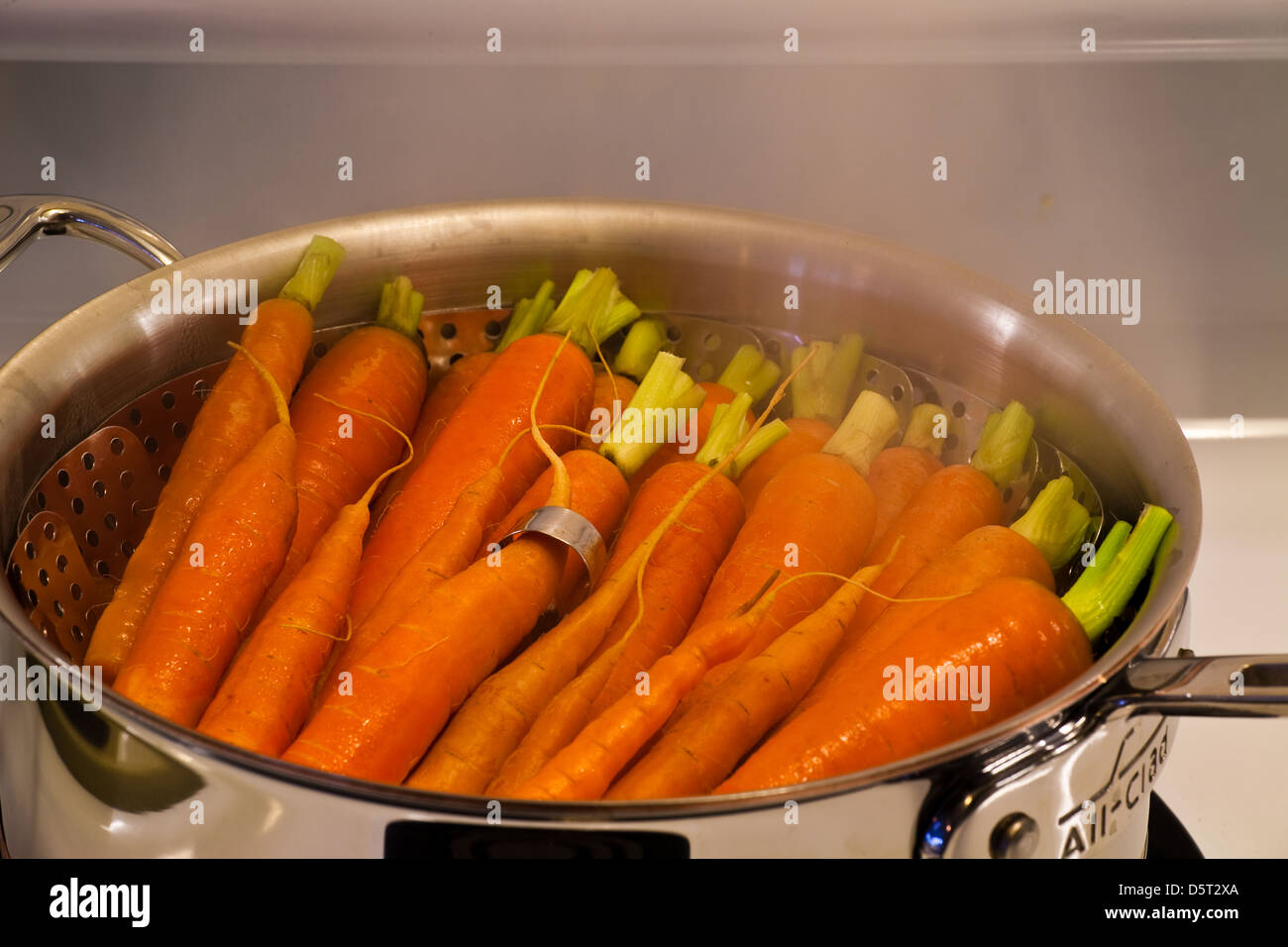 An array of carrots cooking in a steamer Stock Photo