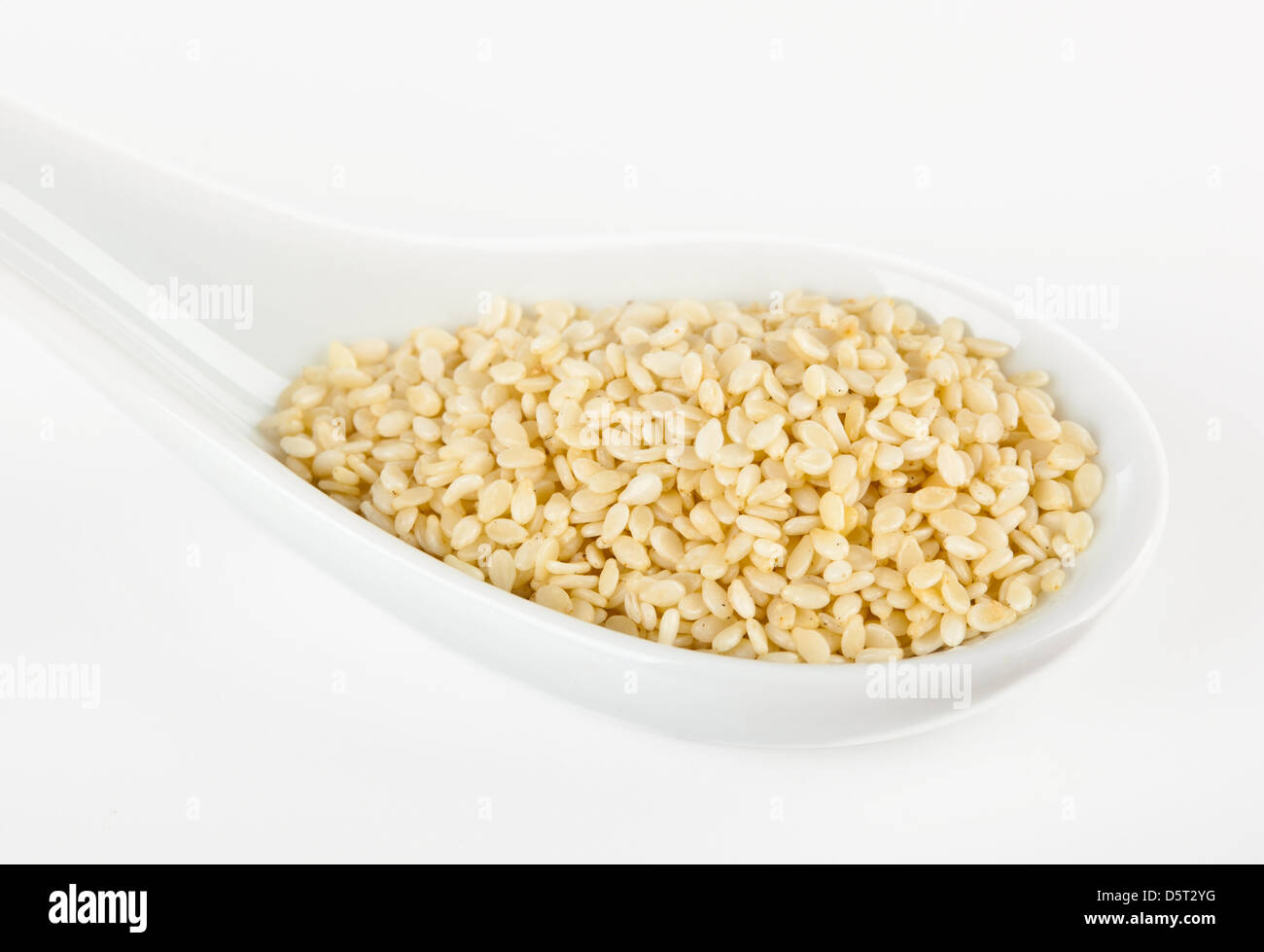 Sesame seeds in the spoon on white background Stock Photo