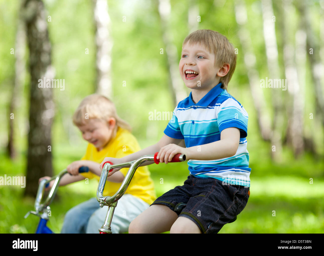 adorable children riding their bikes in park Stock Photo