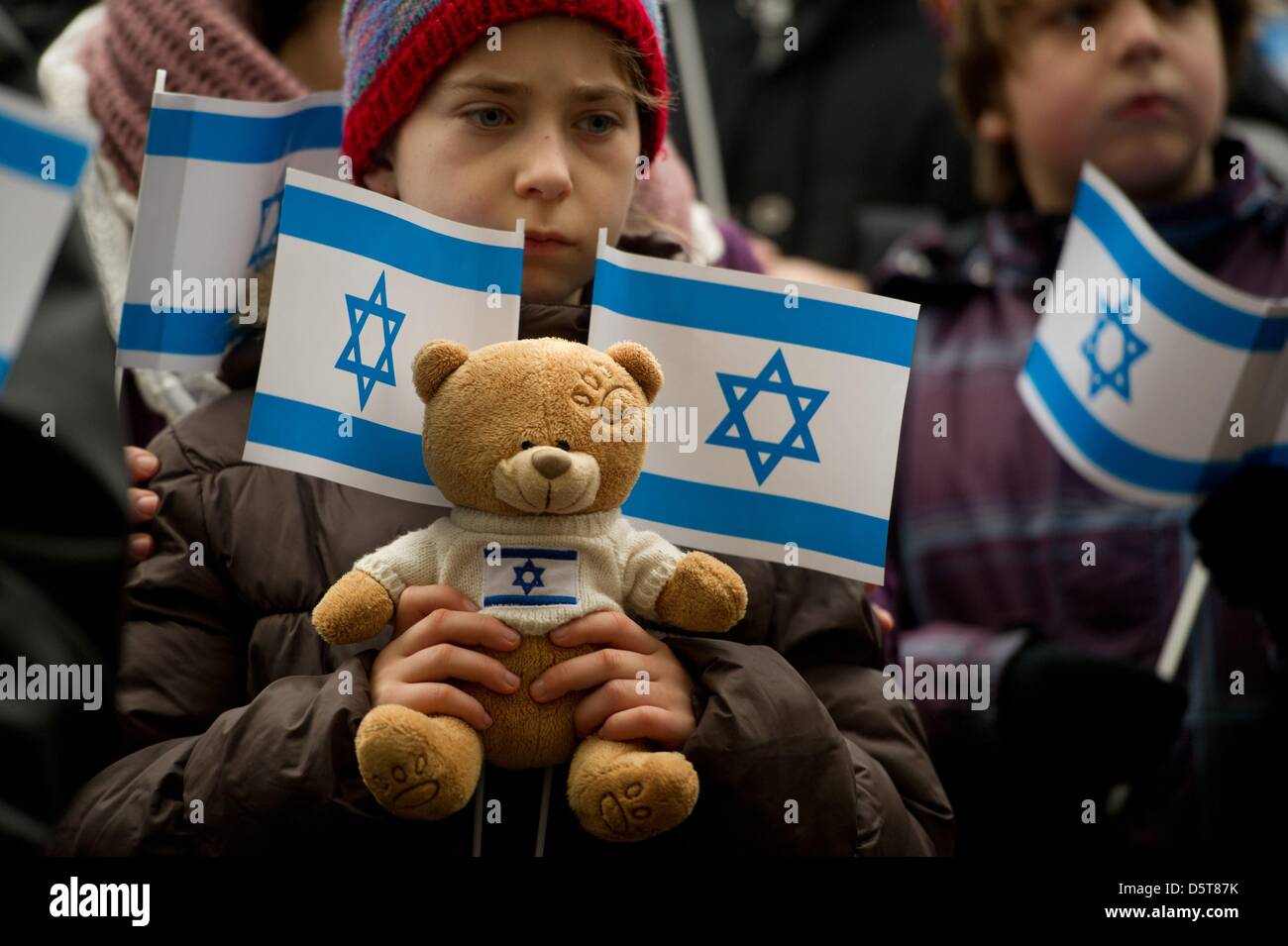 Hannah (9) from Berlin holds flags and a teddy bear during a rally demonstrating solidarity with Israel in Berlin, Germany, 18 November 2012. The rally organized by the Mideast Freedom Forum Berlin wishes to call attention to the situation of Israeli civilians. Photo: SEBASTIAN KAHNERT Stock Photo
