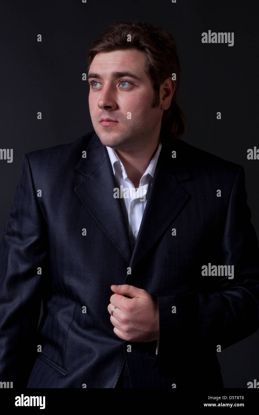 portrait of a young man in a black suit with a gray background Stock ...