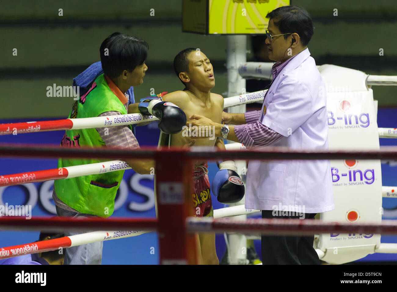 Doctor examining wounded Thai boxer at the Rajadamnern stadium in