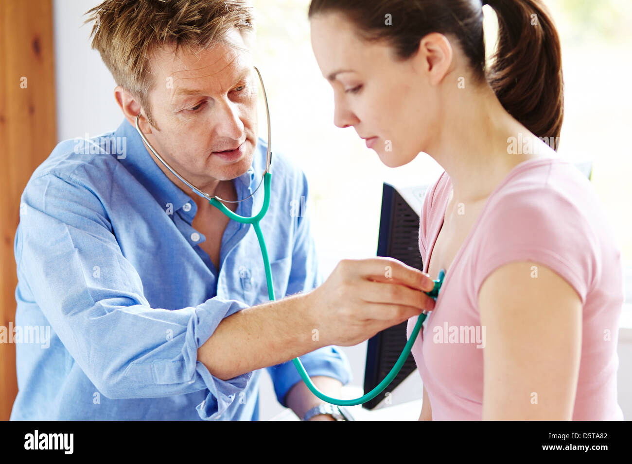 Doctor listening to patients chest Stock Photo Alamy