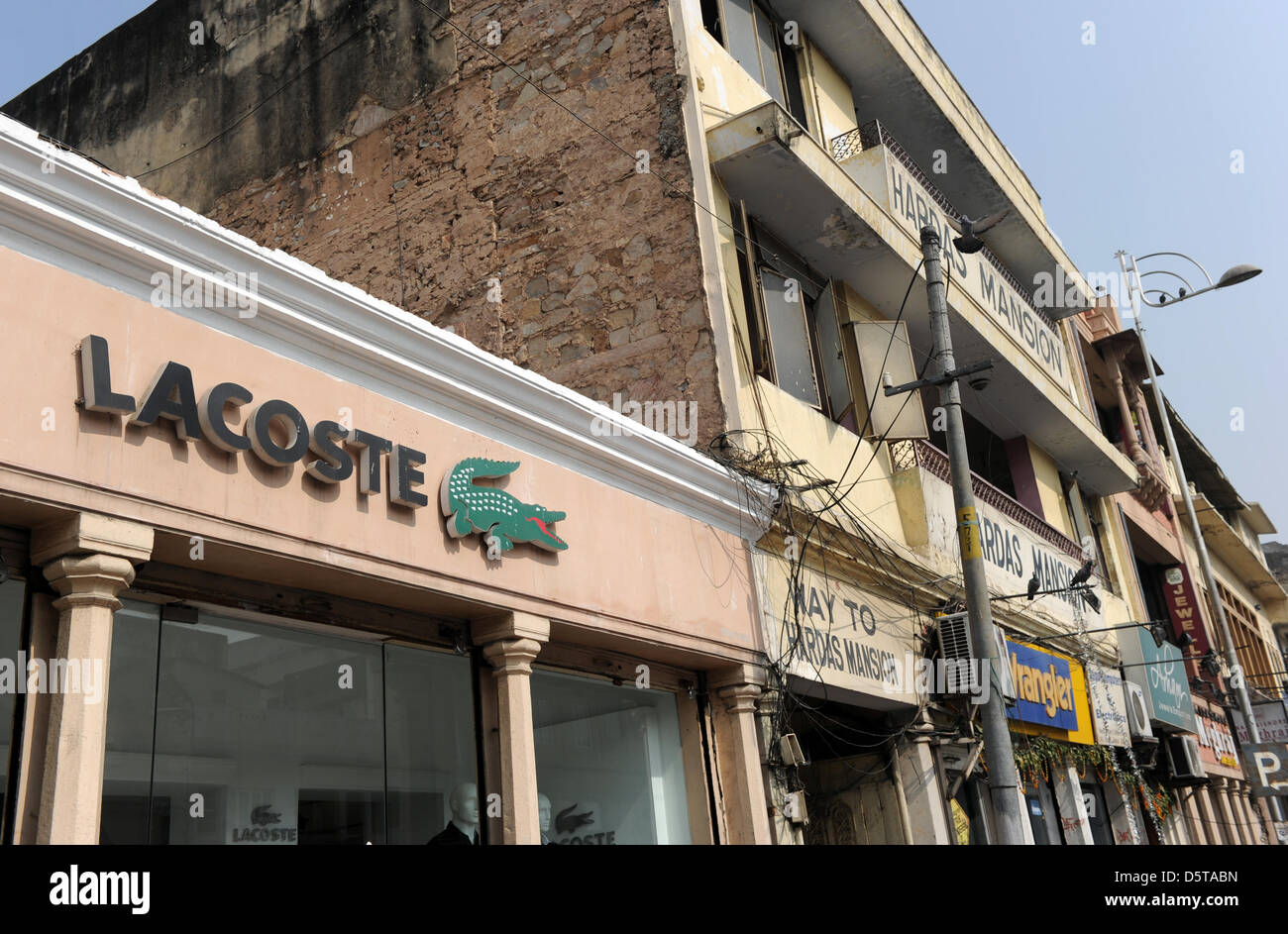 The logo of clothing manufacturer Lacoste hangs above the entrance to a  shop in Jaipur, India, 17 November 2012. Photo: Jens Kalaene Stock Photo -  Alamy