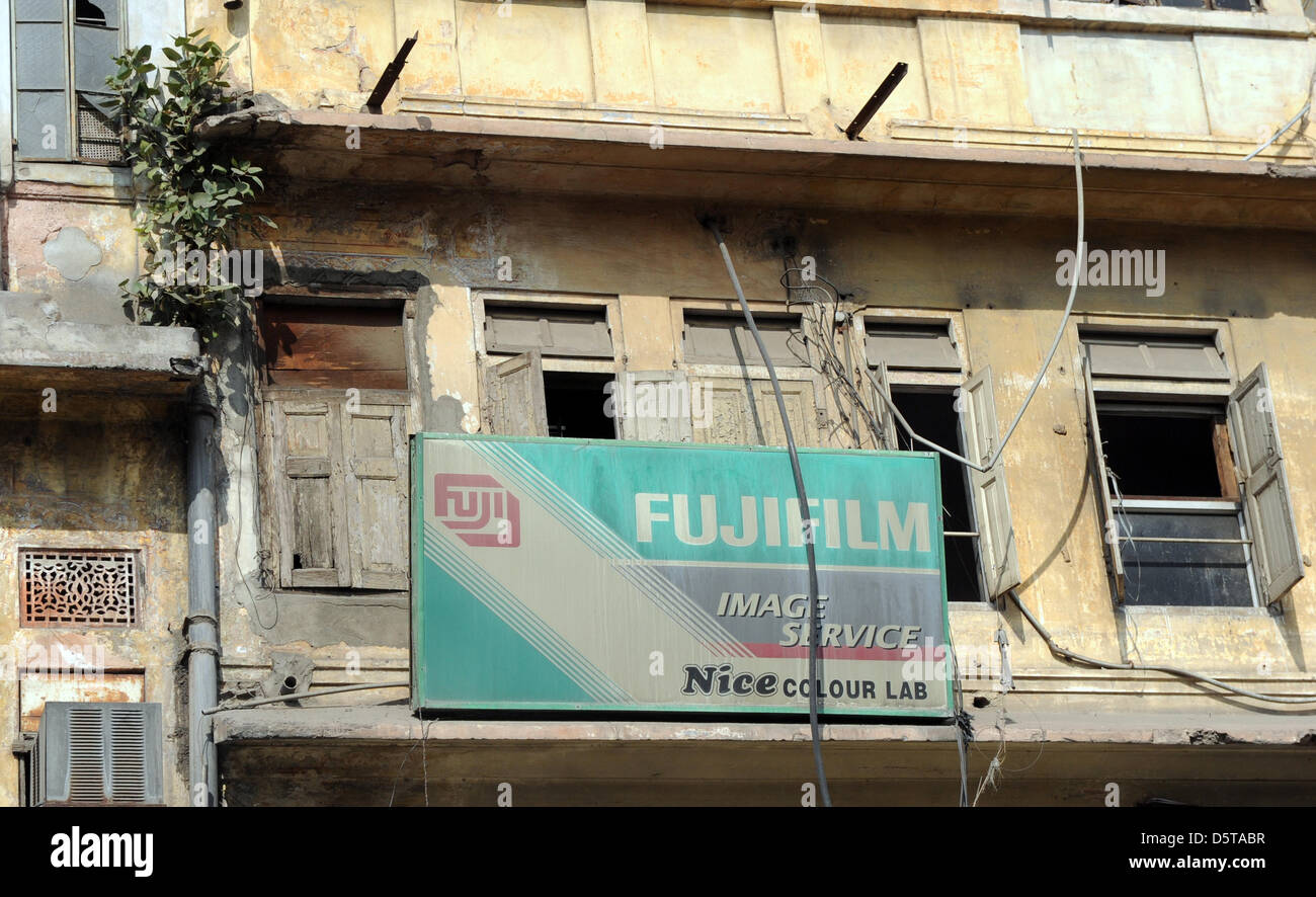 An advertising sign of Fuji film lab hangs from a decaying facade of a residential house in Jaipur, India, 17 November 2012. Photo:  Jens Kalaene Stock Photo