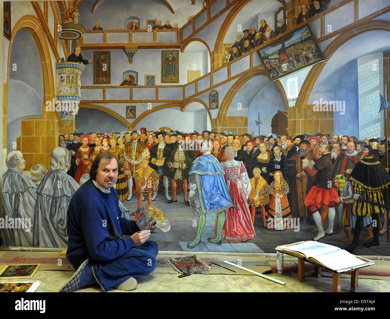 Painter Volker Pohlenz is pictured while working at the painting 'Inauguration of the castle church by Luther on 5 October 1544' at his atelier in Woellnau, Germany, 16 November 2012. The 3.05 m oil painting for the castle church in Torgau depicts among others Martin Luther as well as 71 known historic figures from the time. The painting for the 500-year-anniversary of the reformat Stock Photo