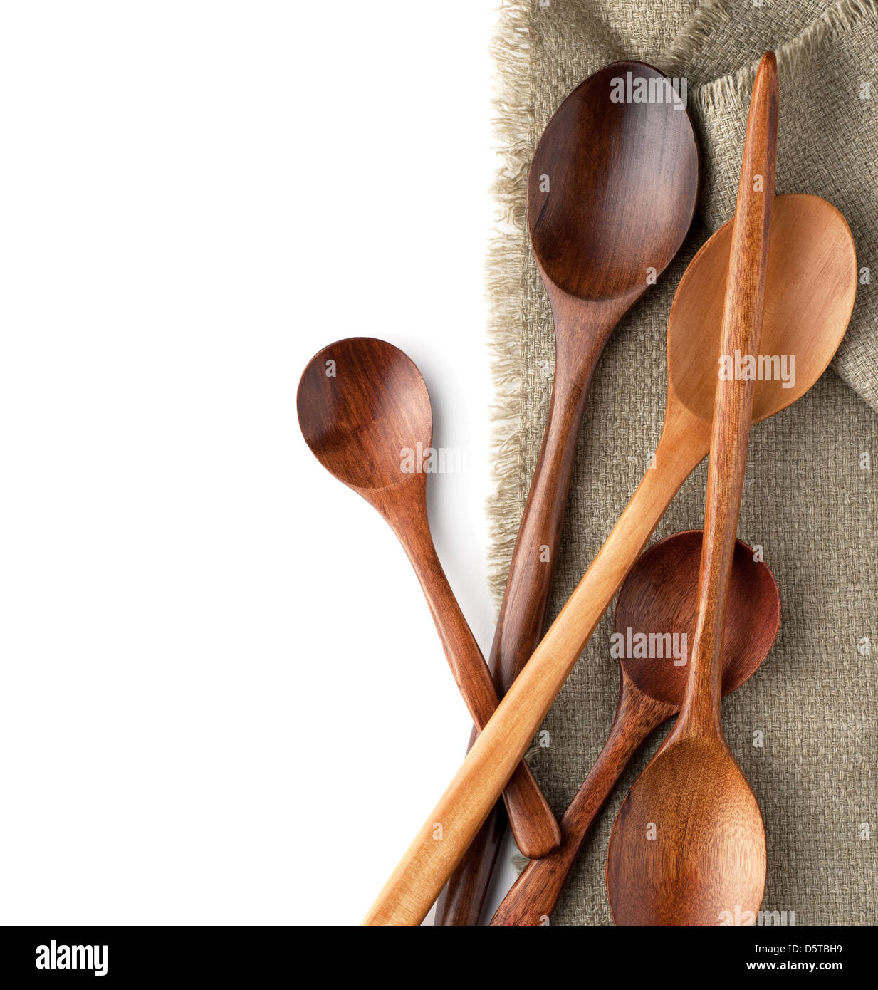 Wooden spoons on a kitchen towel isolated on white background Stock Photo