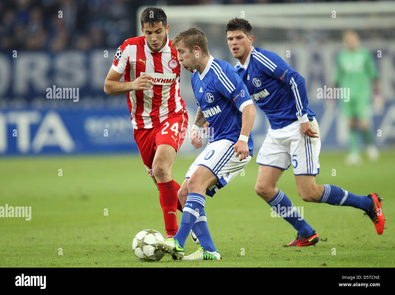 Schalke's Lewis Holtby (C) and Klaas-Jan Huntelaar (R) vie for the ball with Kostas Manolas (L) of Olympiacos Piraeus during the Champions League Group B soccer match between FC Schalke 04 and Olympiacos FC at Stadion Gelsenkirchen, Gelsenkirchen, 21 November 2012. Photo: Friso Gentsch/dpa  +++(c) dpa - Bildfunk+++ Stock Photo