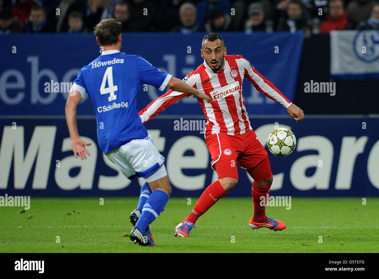 Schalke's Benedikt Hoewedes (L) and Olympiacos' Kostas Mitroglou vie for the ball during the Champions League Group B soccer match between FC Schalke 04 vs Olympiacos FC at Stadion Gelsenkirchen in Gelsenkirchen, Germany, 21 November 2012. The match ended 1:0. Photo: Revierfoto Stock Photo