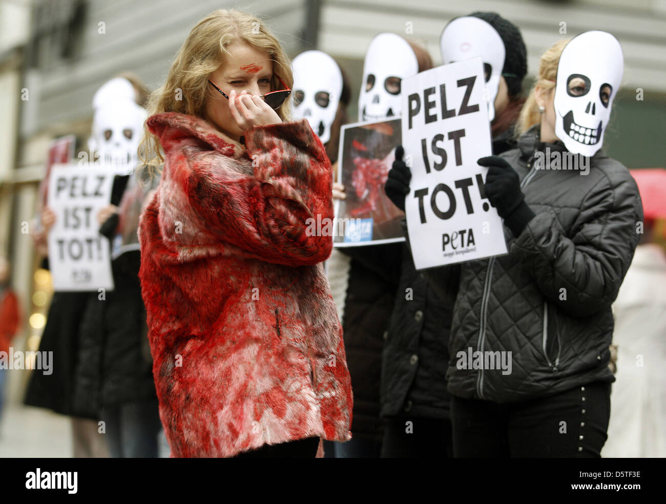Mit blutigen Pelzmänteln protestieren PETA-Aktivistinnen am 23.11.2012 in Düsseldorf (Nordrhein-Westfalen) gegen das Tragen von Pelzmänteln. Anlass der Aktion auf Düsseldorfs Nobeleinkaufsmeile ist der 'Fur-Free-Freiday', der Pelzfreie Freitag.   Foto: Roland Weihrauch/dpa Stock Photo