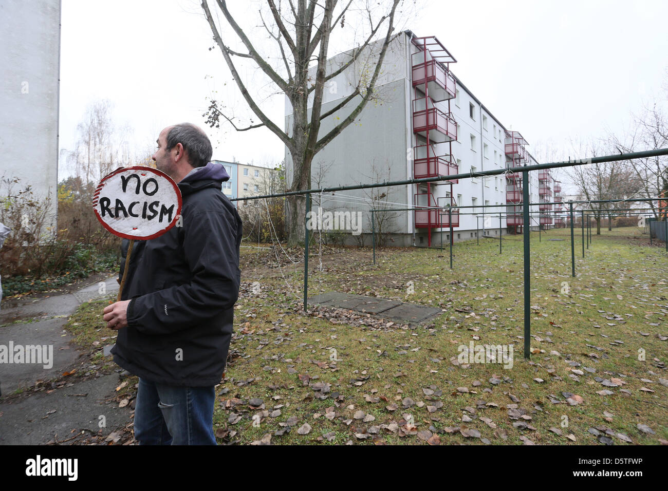 A resident of the Berlin district Johannisthal holds a sign which reads 'No Racism' in Berlin, Germany, 24 November 2012. Residents attended the so-called neighborhood cleaning walk to remove right-wing propaganda in the hood. Photo: STEPHANIE PILICK Stock Photo