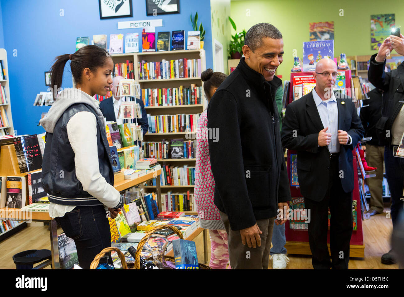 United States President Barack Obama, center, and daughter Malia, left, shop at One More Page Books in Arlington, Virginia on Small Business Saturday, November 24, 2012..Credit: Kristoffer Tripplaar / Pool via CNP..Pool Report 1: Motorcade left the South Lawn [of the White House] at 1:02 p.m. and arrived in Arlington, Virginia, at One More Page Books at 1:15 p.m. for an OTR (Off th Stock Photo