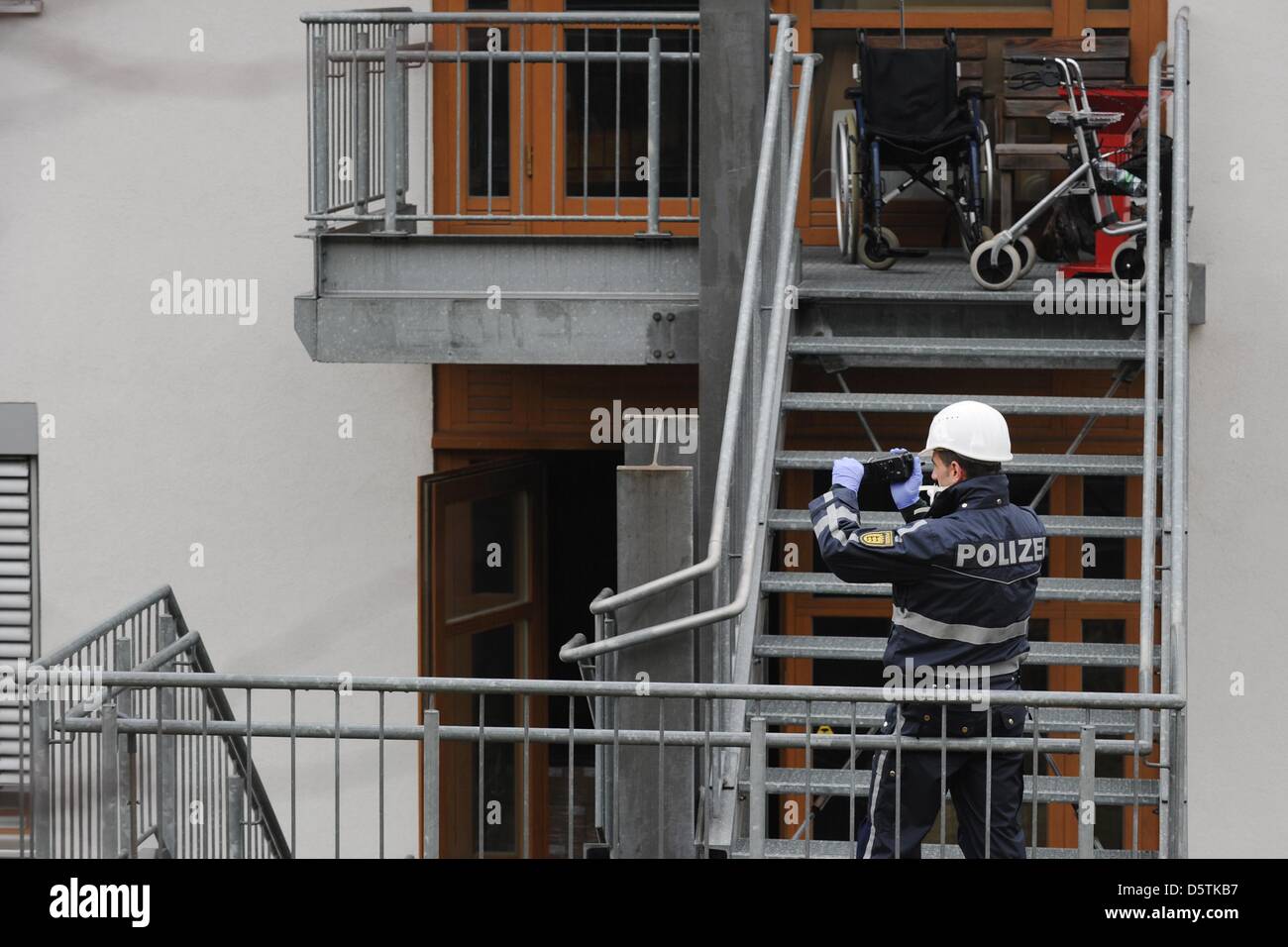 A police officer films in front of a workshop for people with disabilities in Titisee-Neustadt, Germany, 27 November 2012. 14 people were killed on 26 November when a fire spread through the workshop. Photo: FELIX KAESTLE Stock Photo
