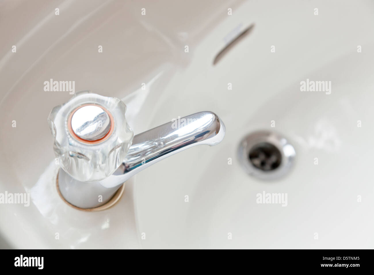 Hot tap and wash basin in a bathroom Stock Photo