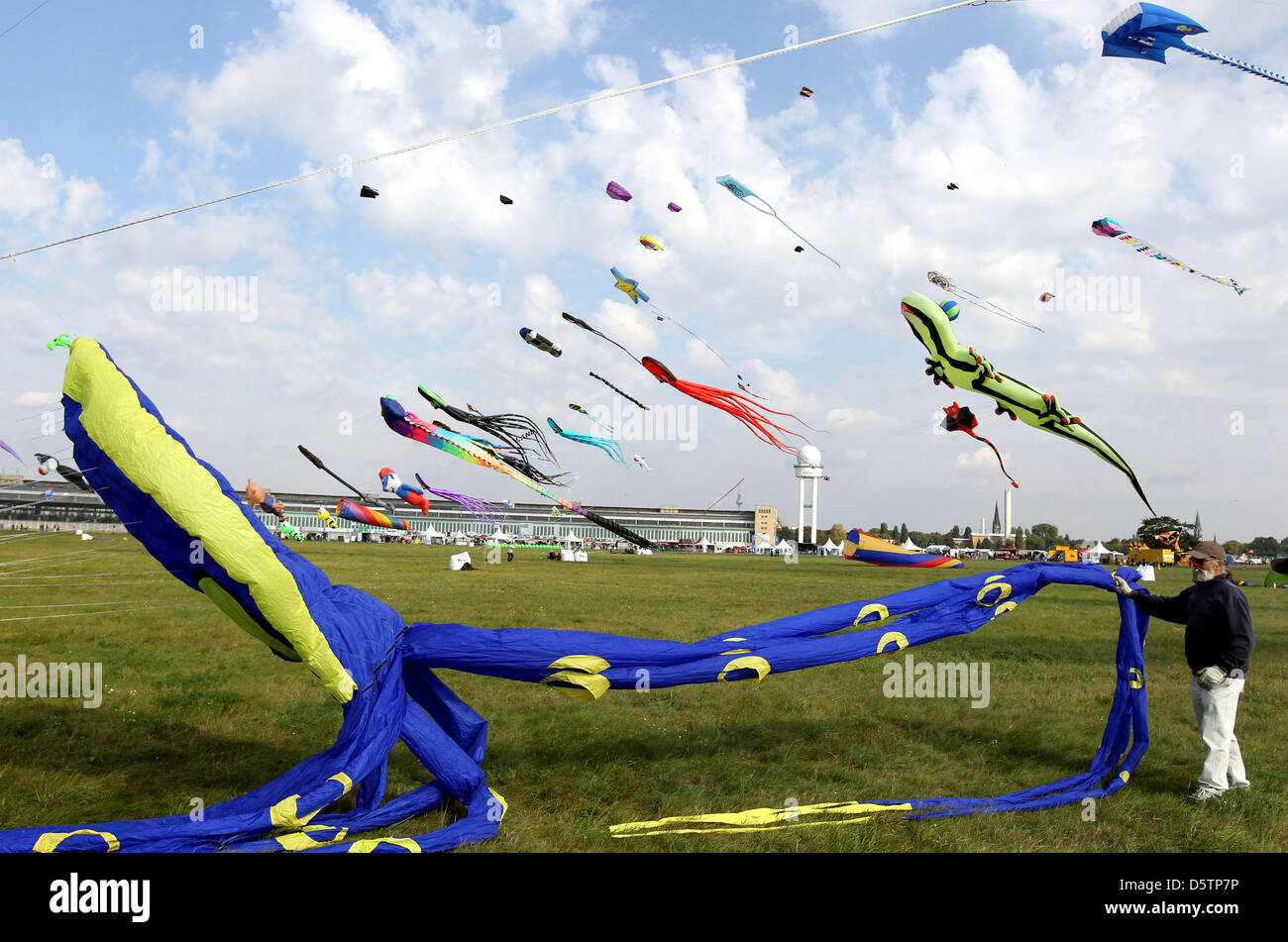 Visitors watch colourful kites at a kite festival on the former Tempelhof airport in Berlin