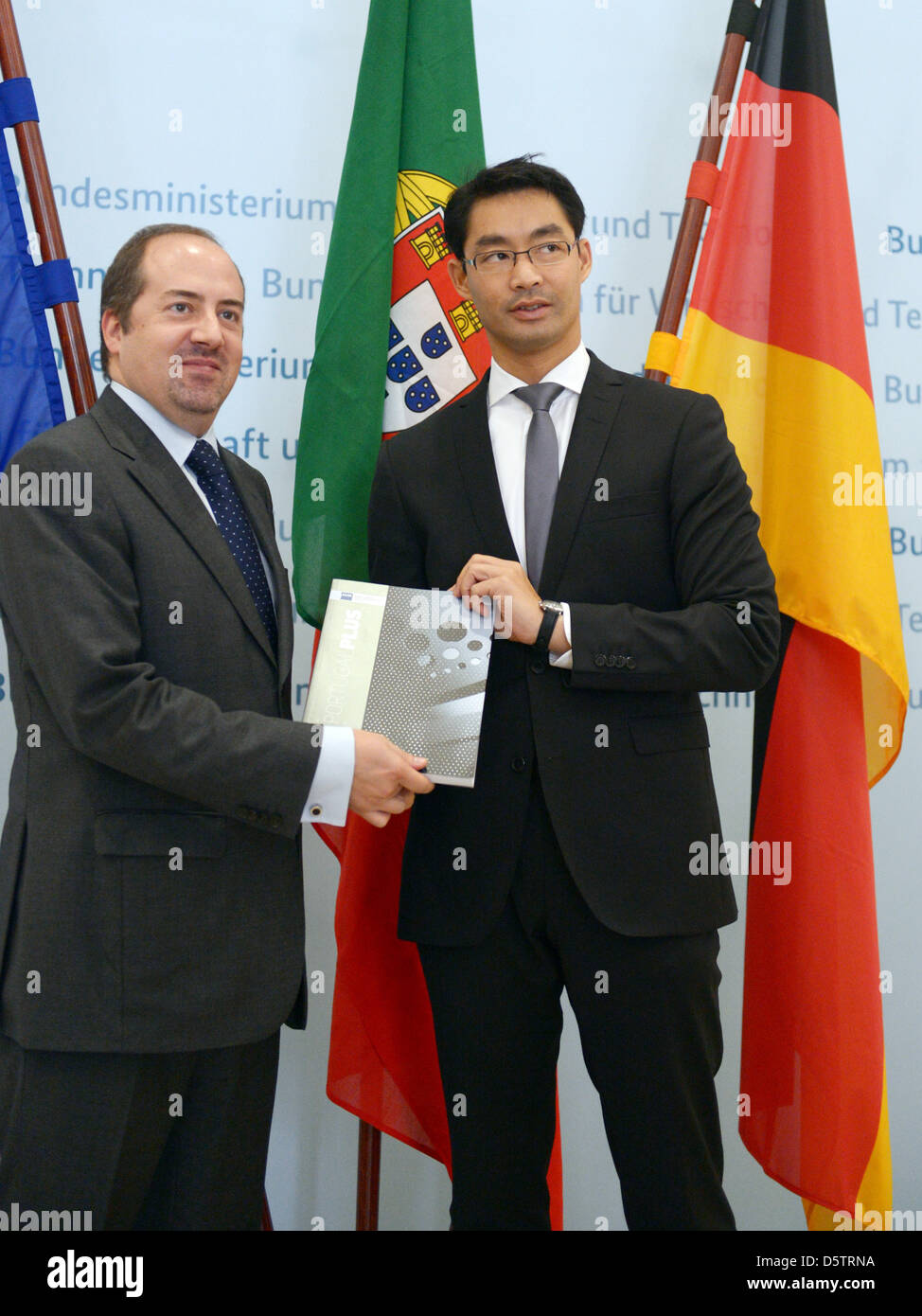 German Economy Philipp Roesler (R) and his Portuguese counterpart Alvaro Santos Pereira hold a book lettered 'Portugal Plus' at the Ministry of Economics in Berlin, Germany, 25 September 2012. Both politicians open a roadshow of Portuguese export companies today, which is part of the initiative 'Portugal PLUS'. The program intends to presents Portuguese suppliers to German companie Stock Photo