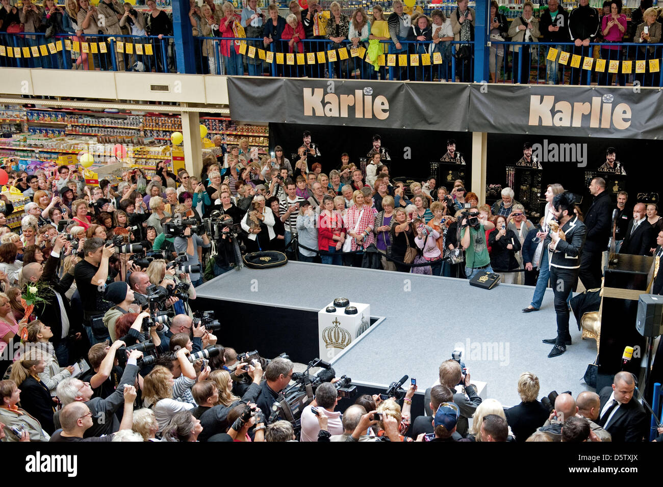 Fashion designer Harald Gloeoeckler (R) holds a tiny dog in his arms at a branch of pet shop chain 'Futterhaus' in Berlin-Britz, Germany, 27 September 2012. The designer presented his first collection for dogs 'Gloeoeckler Dog Couture by Karlie'. Photo: Robert Schlesinger Stock Photo