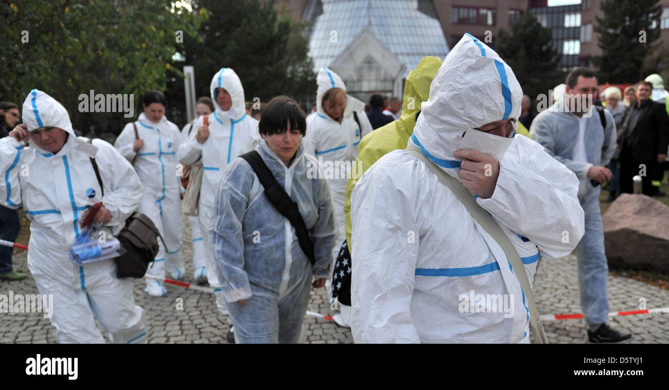 Employees of a Deutsche Bank base leave their workplace in security clothes in Schkanditz, Germany, 28 September 2012. An envelope with white powder was found in the post. It is yet unclear whether the envelope contains the dangerous anthrax virus. 700 people were evacuated from the building. Photo: HENDRIK SCHMIDT Stock Photo