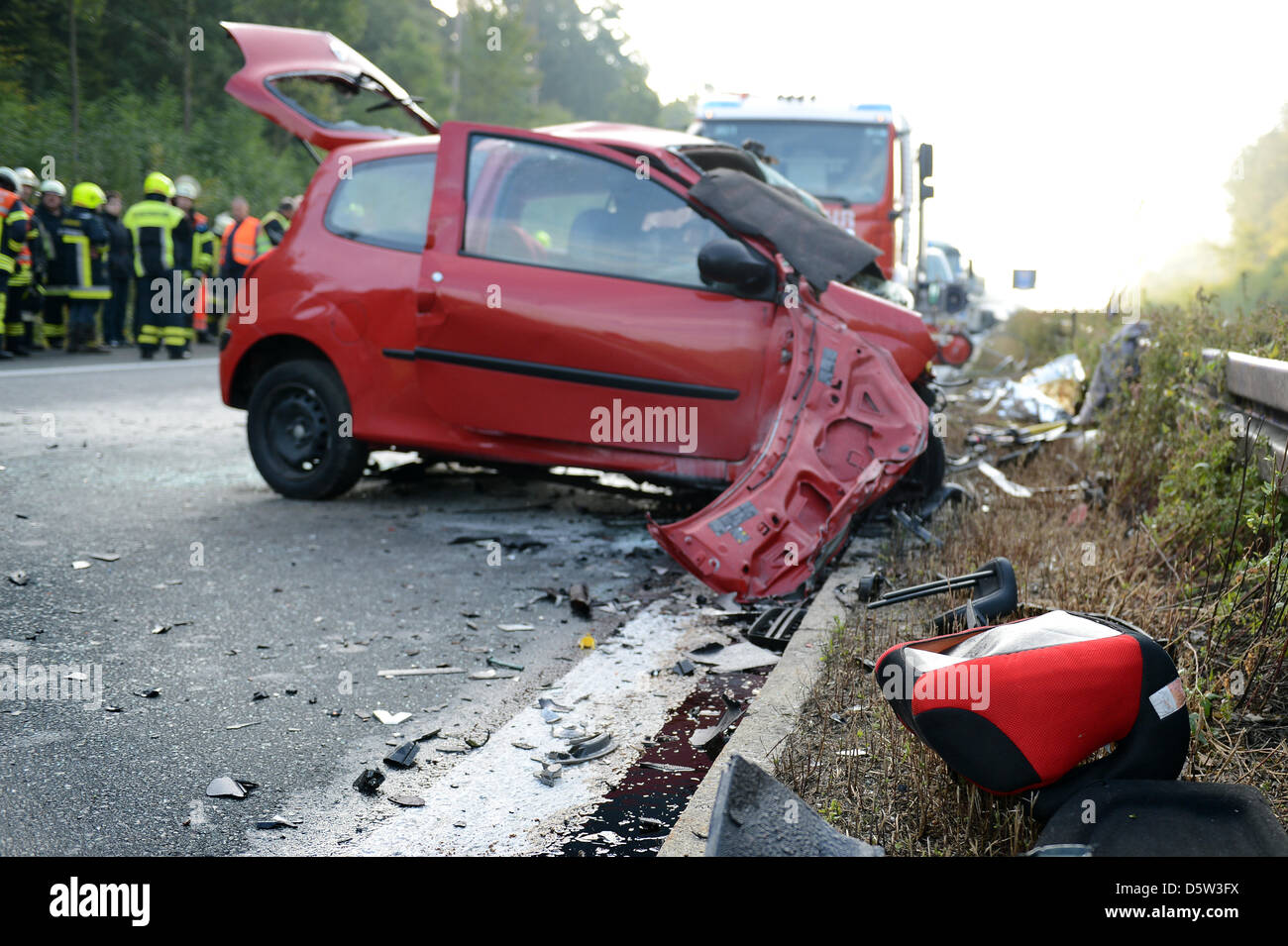 Emergency workers stand next to the severely damaged car of a ghost driver after a crash on Autobahn 73 near Hirschaid, Germany, 02 October 2012. A 31-year-old woman collided head-on with another car. The woman, a seven-year-old child and the driver coming in the opposite direction died at the scene. Photo: David Ebener Stock Photo
