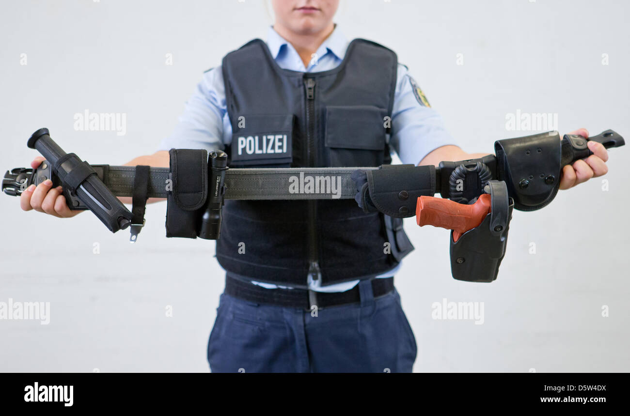 A police officer trainee holds a belt with a rubber gun during an