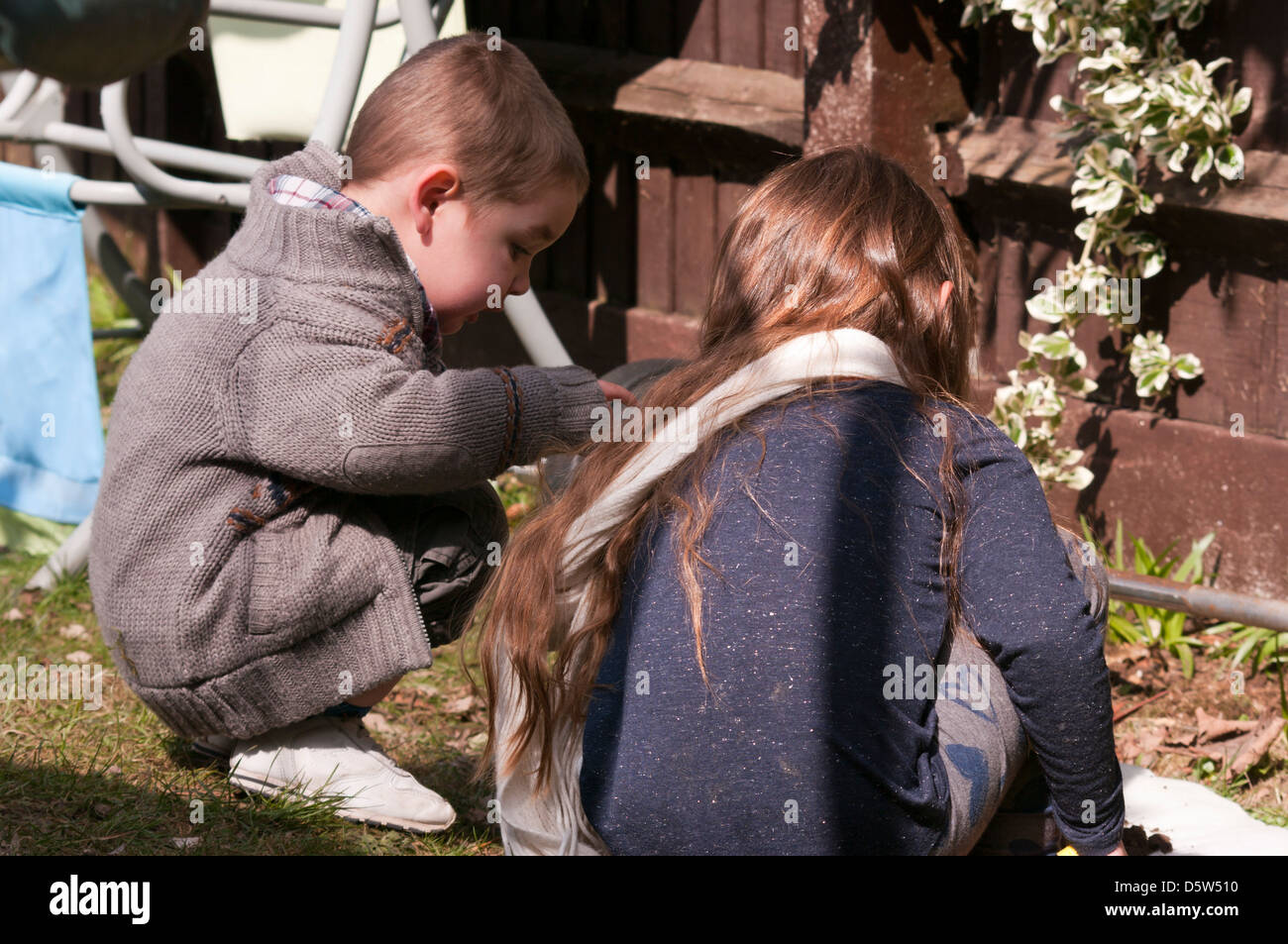 Young Brother and Sister Playing Together In The Garden Stock Photo - Alamy