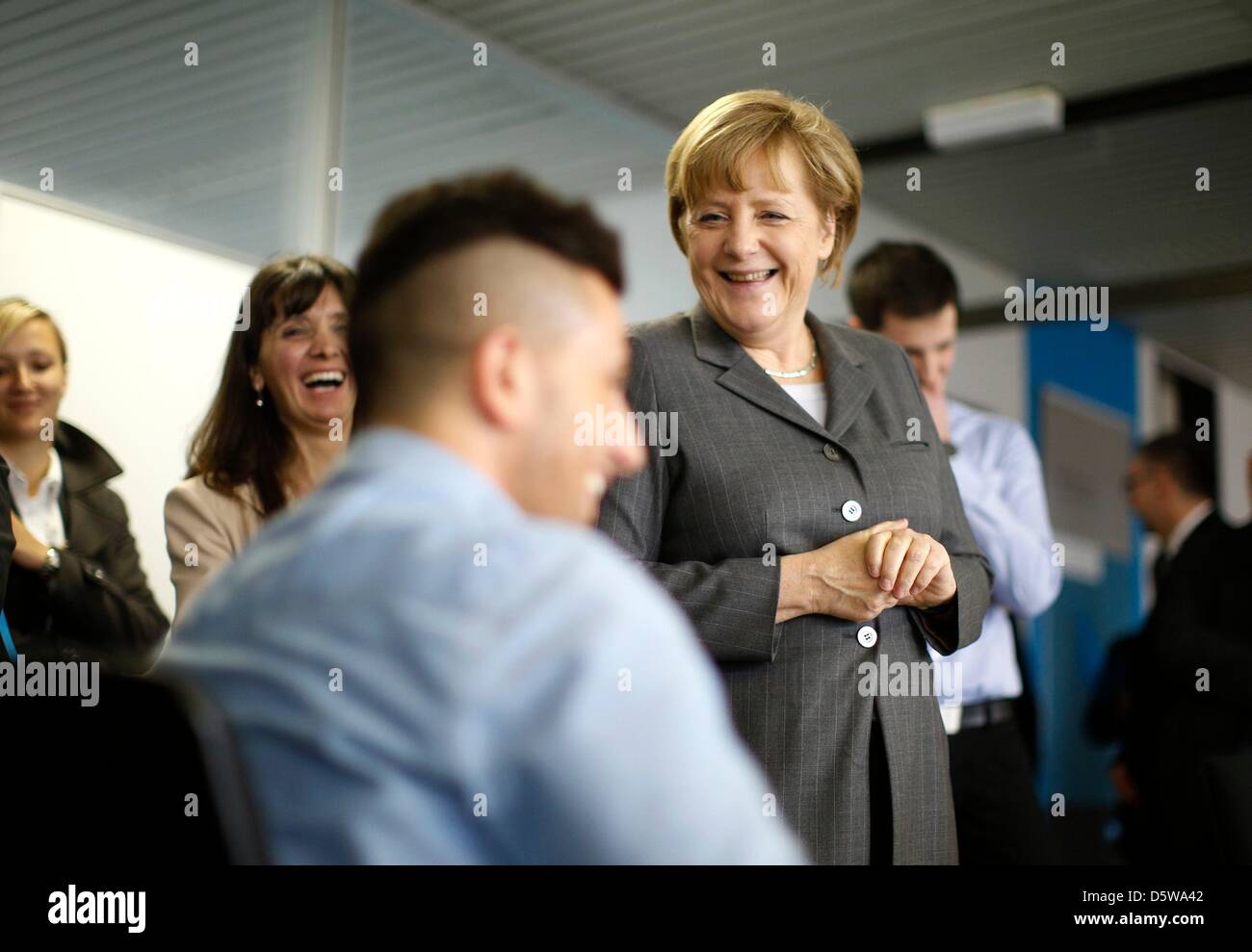 German Chancellor Angela Merkel talks with a trainee during a visit to the pneumatic systems producing company Mader GmbH in Leinfelden-Echterdingen near Stuttgart April 9, 2013, as part of a demography tour. Photo: Lisi Niesner/dpa +++(c) dpa - Bildfunk+++ Stock Photo