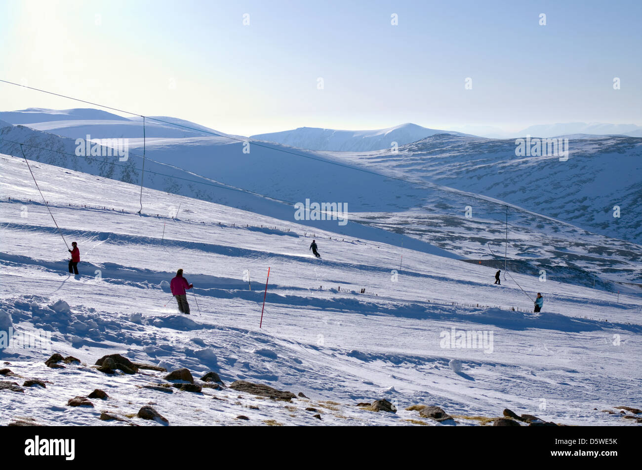 Skiers & snowboarders on tows and runs, seen from the Ptarmigan viewing terrace, Cairngorm Mountain Ski Centre Aviemore Scotland Stock Photo