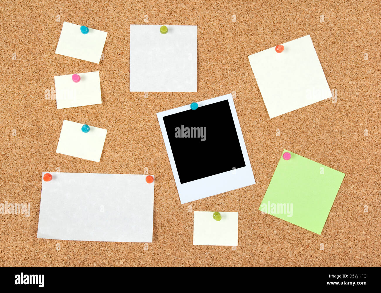 Postit notes of different sizes and a blank photo pinned to corkboard