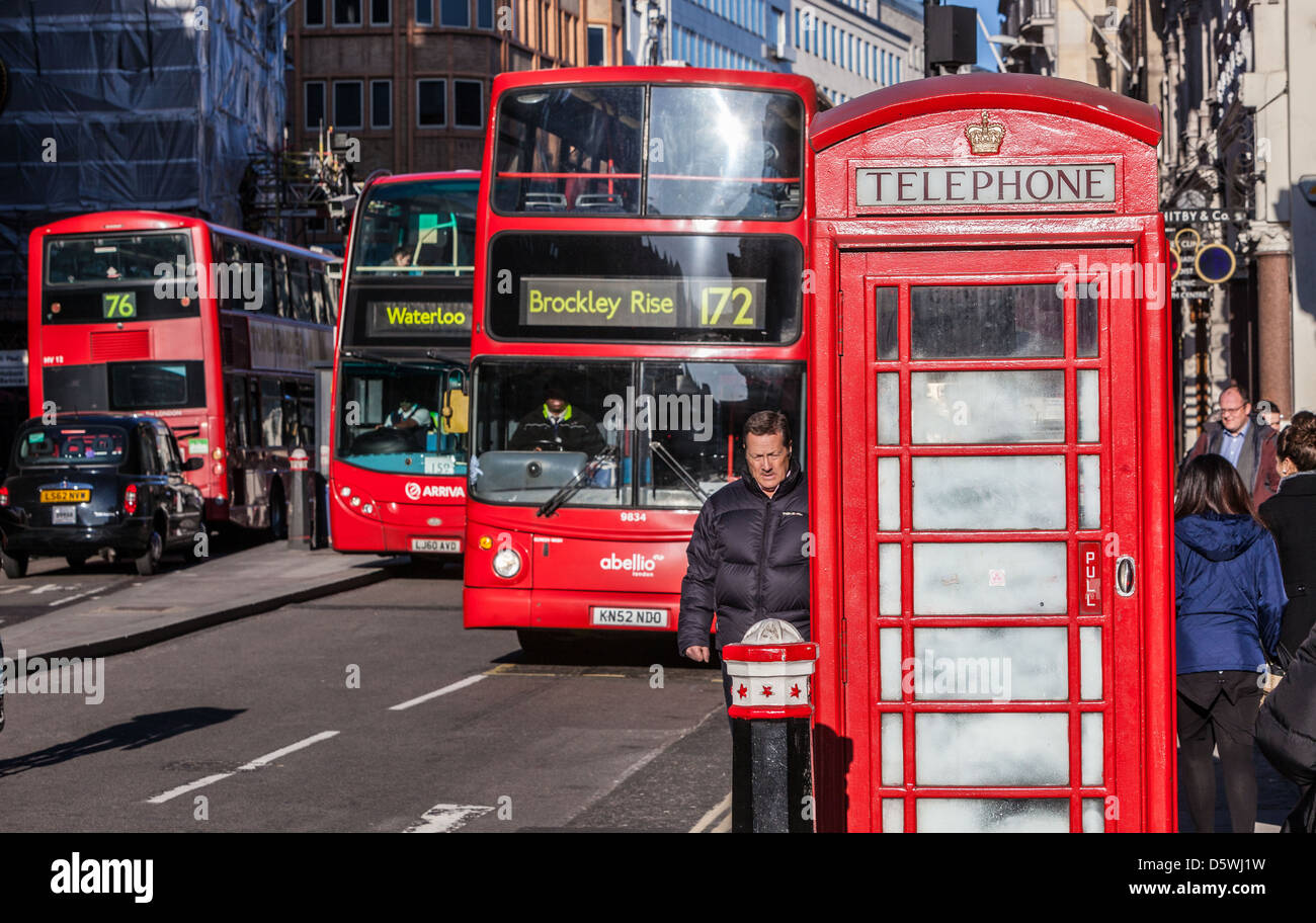 REd telephone booth against red buses, London, England, UK. Stock Photo